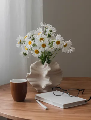 Vase of daisies on a desk